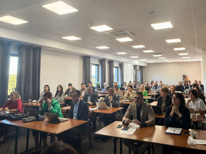 Uczestnicy spotkania siedzący w ławkach